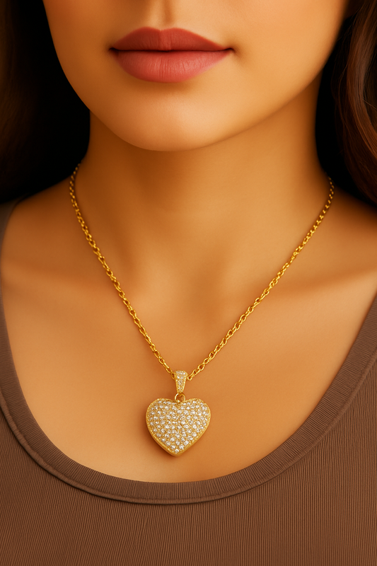 Close-up of a person wearing a gold heart-shaped necklace with a brown top.